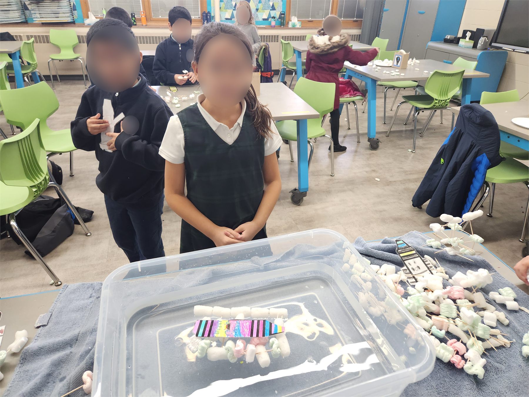 Student smiling beside a floating crayon raft