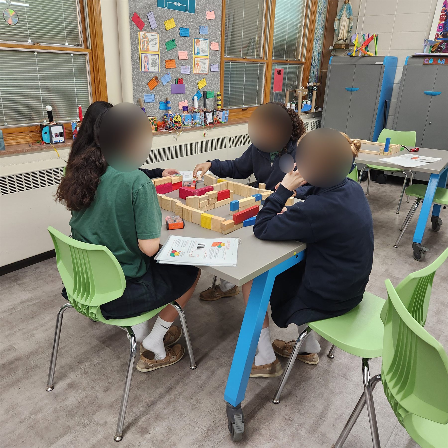 Students working together with Edison robots and blocks