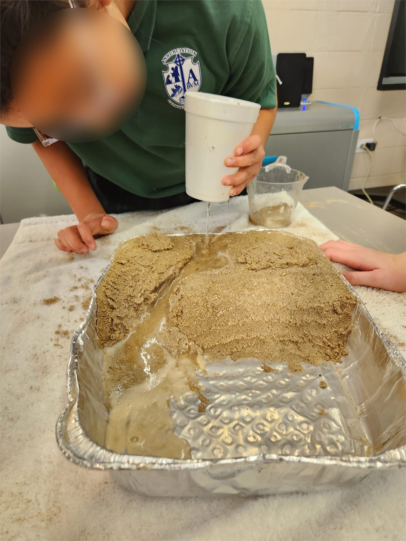 Students testing erosion in a tray of sand